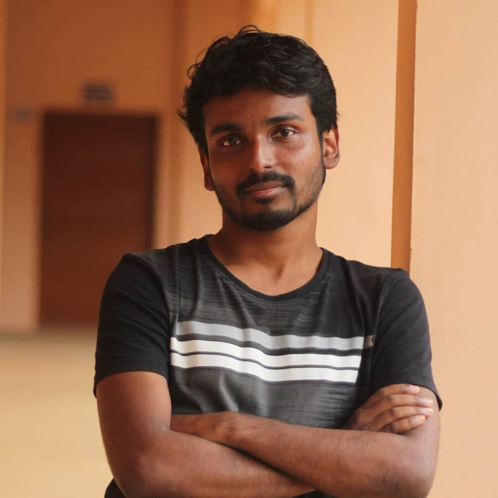 A photo of Pranav leaning on a column with arms folded