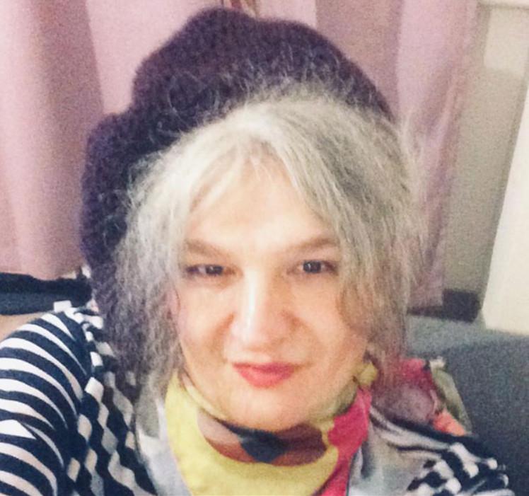 a photo of Eylem in a striped shirt with a beret and handkerchief around her neck