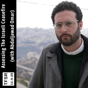 Abdaljawad Omar wearing glasses and looking at the camera from the foreground with a West Bank city behind him
